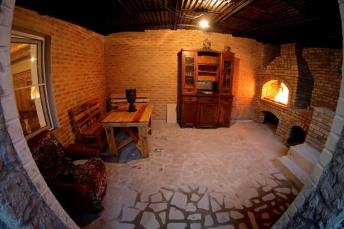 Habitación con mesa de madera y chimenea. en Vanand Guest House en Gyumri