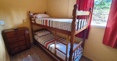 two bunk beds in a room with a window at CASA GIRASSOL-Trilha das Flores-SERRA DA CANASTRA in São Roque de Minas