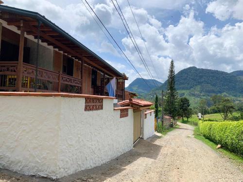 a house on a dirt road with mountains in the background at Apartamento cerca a cascada del Amor,Wifi in Jardin