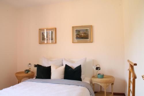 a bedroom with a bed and two pictures on the wall at Casa Cecilia, 2 bedrooms, 1 bathroom, lake view, pool in Gardone Riviera