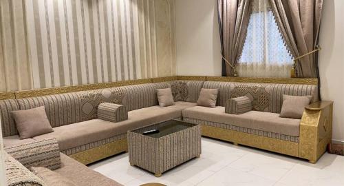 a living room with a couch and a table at منتجع قرية الريف الفندقية in Taif