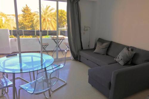 ein Wohnzimmer mit einem Glastisch und einem Sofa in der Unterkunft Cosy studio with pool in Port d'Alcúdia