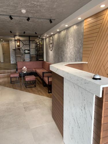 a lobby with a counter and a bar with chairs at Vertoni Hotel Yerevan in Yerevan