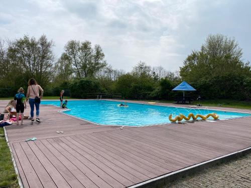 a group of people standing around a swimming pool at Vakantiehuisje Makkum NL - S15 in Makkum