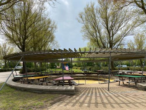 a pavilion with tables and benches in a park at Vakantiehuisje Makkum NL - S15 in Makkum