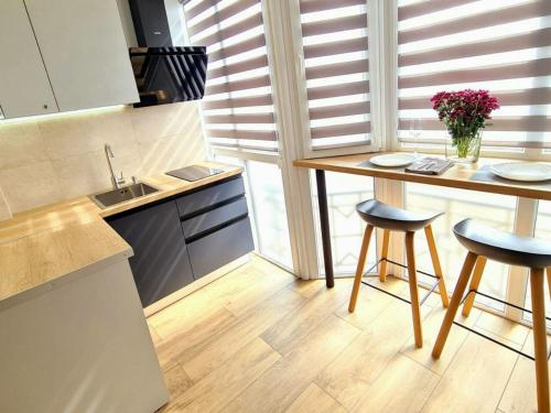 a kitchen with a wooden table and two stools at PremierAtlant in Dnipro