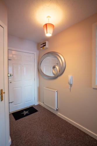 a hallway with a white door and a mirror at Ample Comforts, Centrally Located, Town Centre in Warrington