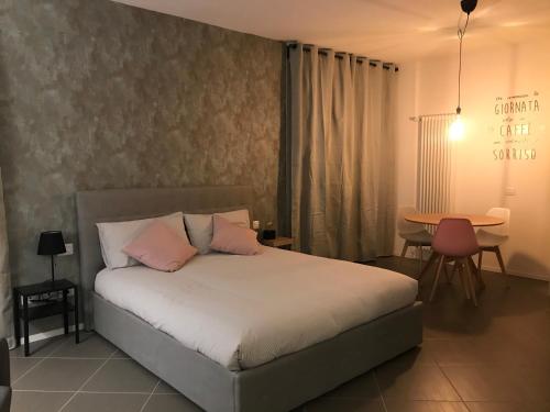 um quarto com uma cama com almofadas cor-de-rosa e uma mesa em Home Sweet Home em Scandicci