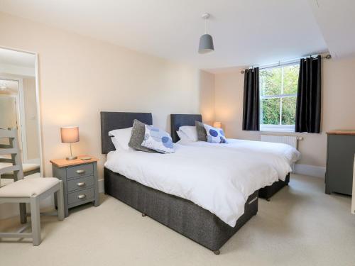 Un dormitorio con dos camas y una silla y una ventana. en 12 Combehaven, en Salcombe