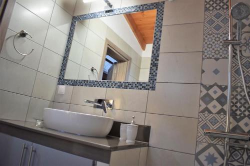 een badkamer met een wastafel en een spiegel bij House Gylisma in Kámbos