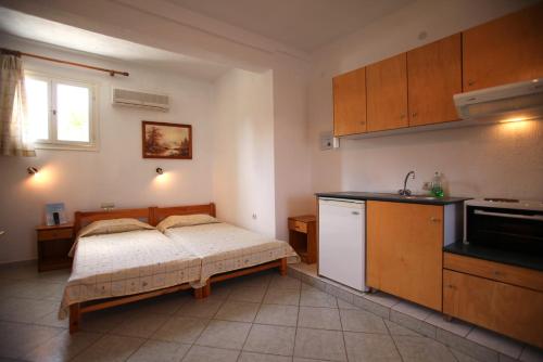 eine Küche mit einem Bett und einem Waschbecken in einem Zimmer in der Unterkunft Alexandros Rooms & Studios in Skopelos