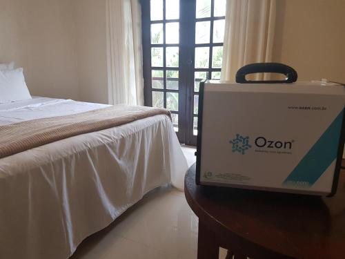a suitcase sitting on a table next to a bed at Indaiá Praia Hotel in Bertioga