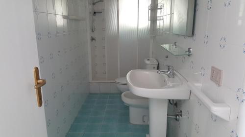 biała łazienka z umywalką i toaletą w obiekcie Casa Vacanza Santorsola w mieście Trinità dʼAgultu