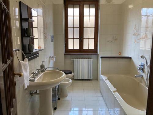a bathroom with a sink and a tub and a toilet at VILLA FERNANDO in Castagnole Lanze