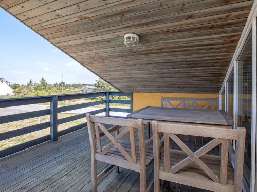 una terraza de madera con mesa y bancos. en 10 person holiday home in Thisted, en Nørre Vorupør