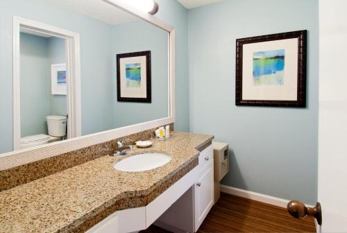a bathroom with two sinks and a mirror at The King and Prince Beach & Golf Resort in Saint Simons Island
