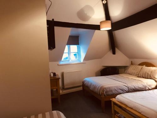 a bedroom with two beds and a window at Severn Valley Guest House in Bewdley