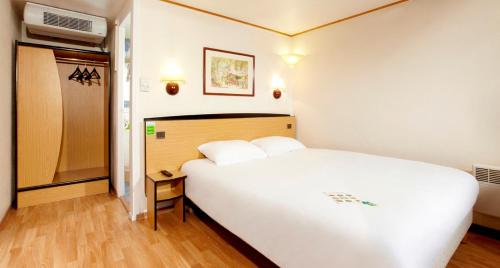 a bedroom with a large white bed in a room at Campanile Manosque in Manosque