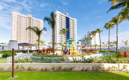 um parque com parque infantil e edifícios e palmeiras em Salinas Exclusive Resort em Salinópolis