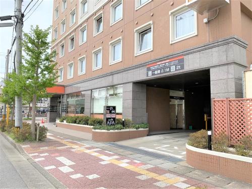 a building with a parking lot in front of it at APA Hotel Miyagi Furukawa-Ekimae in Osaki