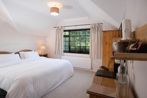 a bedroom with a white bed and a window at Woodside Lodge B&B in Westport