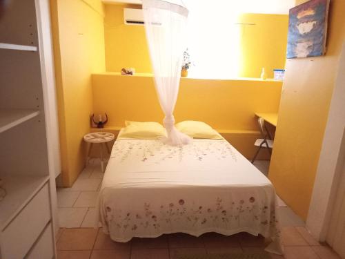 a small room with a bed with a veil on it at Bel Appartement - proche des plages de Sainte Anne in Sainte-Anne