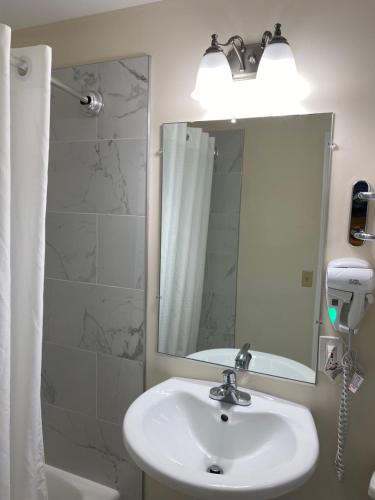 uma casa de banho com um lavatório e um espelho em Villager Motel em Williamstown