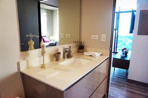 a bathroom with a sink and a large mirror at Amazing views SJO, Cozy, Equipped. 24/7 Concierge in San José