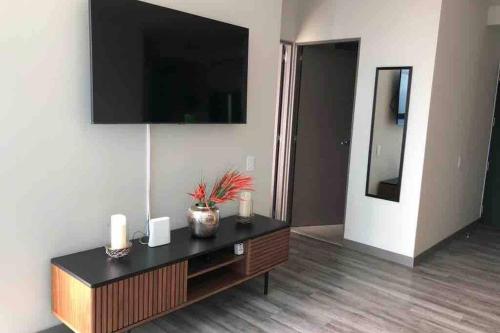 a living room with a flat screen tv on a wall at Amazing views SJO, Cozy, Equipped. 24/7 Concierge in San José