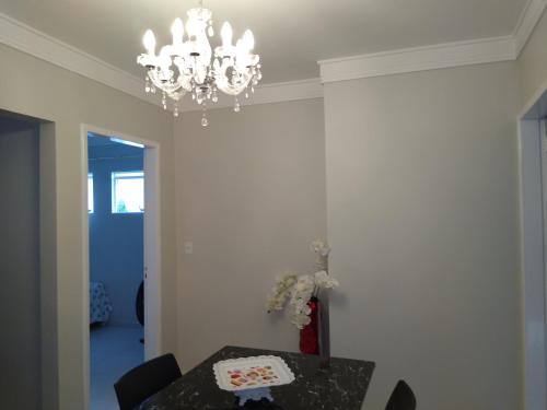 a dining room with a table and a chandelier at Apartamentos aconchegantes in Teresina