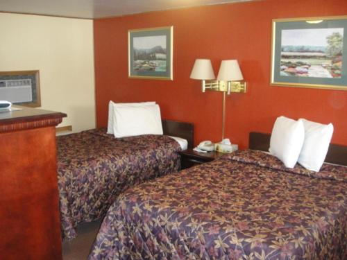 two beds in a hotel room with red walls at Standish Motel in Standish