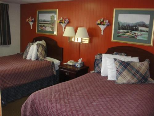 2 Betten in einem Hotelzimmer mit roten Wänden in der Unterkunft Standish Motel in Standish