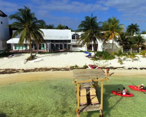 a house on a beach with people on surfboards in the water at CANCUN PRIVATE APARTMENT in Cancún