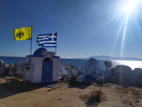 a small chapel with a flag and a cross at Aegean View Seaside Apartment in Kavala