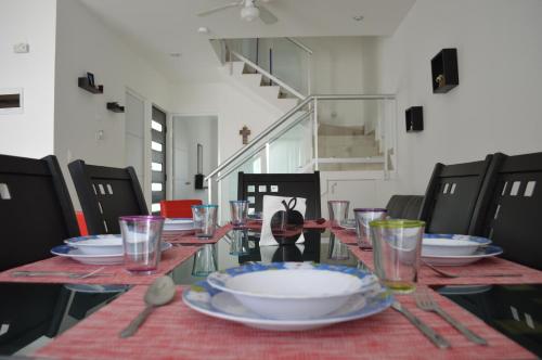 a table with plates and glasses on top of it at CasaMEXH Veredas - Ideal para familias, vacaciones o homeoffice a10 min de la playa in Puerto Morelos