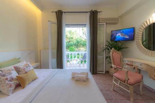 Villas Margaris في كالاماكي: غرفة نوم بسرير ومكتب ونافذة