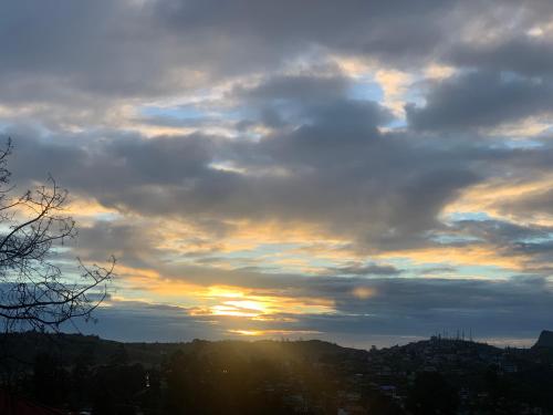 a cloudy sky with the sun setting behind a city at Heaven Seven Nuwara Eliya in Nuwara Eliya