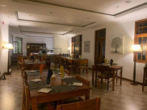 a dining room with wooden tables and chairs at Heaven Seven Nuwara Eliya in Nuwara Eliya