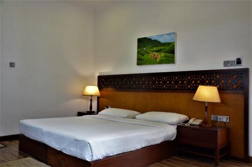 a bedroom with a large bed with white sheets at Heaven Seven Nuwara Eliya in Nuwara Eliya