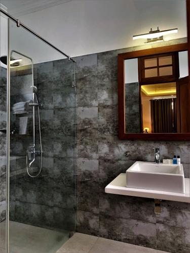 a bathroom with a sink and a glass shower at Heaven Seven Nuwara Eliya in Nuwara Eliya