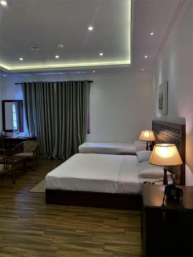 a bedroom with a bed and a desk and two lamps at Heaven Seven Nuwara Eliya in Nuwara Eliya