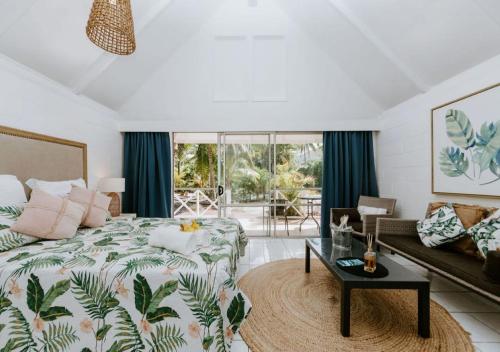una camera da letto con un letto, un divano e un tavolo di The Passage Villas a Rarotonga