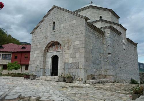 an old stone church with a cross on top of it at Apartments Ravno in Pluzine