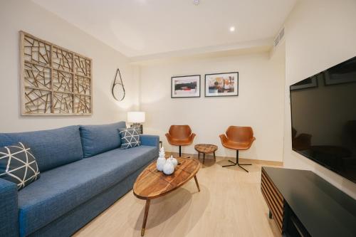 a living room with a blue couch and a table at Debambú Atarazanas in Málaga