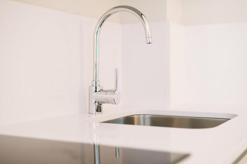 a stainless steel sink in a white kitchen at Debambú Atarazanas in Málaga