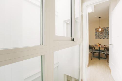 a hallway with windows and a table in a room at Debambú Atarazanas in Málaga