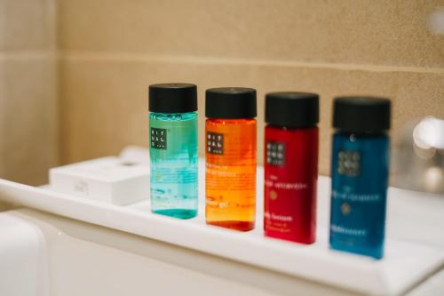 three bottles of paint sitting on a shelf in a bathroom at Debambú Atarazanas in Málaga