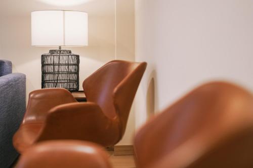 a living room with two brown chairs and a lamp at Debambú Atarazanas in Málaga