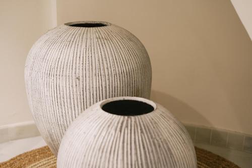 two white vases sitting next to each other at Debambú Atarazanas in Málaga