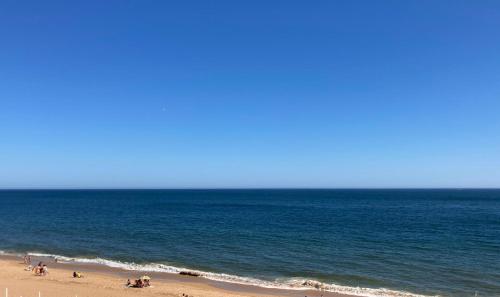 een groep mensen op een strand bij de oceaan bij Casa da Praia in Albufeira